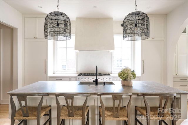 1401 Heather Ln, Charlotte, NC 28209 - kitchen featuring custom exhaust hood, decorative light fixtures, and white cabinets