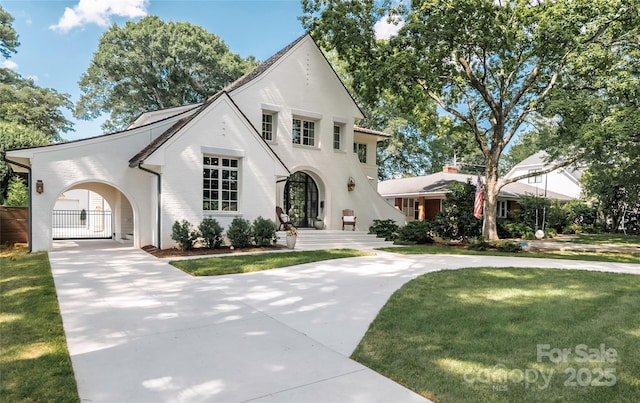 1401 Heather Ln, Charlotte, NC 28209 - tudor house with concrete driveway, a gate, and brick siding