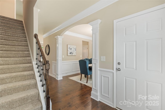 10806 Cove Point Dr, Charlotte, NC 28278 - entrance foyer featuring dark wood-style flooring, decorative columns, arched walkways, wainscoting, and stairway