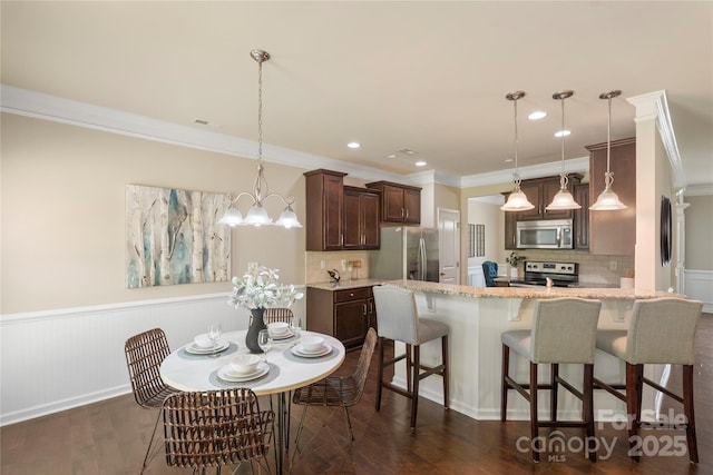 10806 Cove Point Dr, Charlotte, NC 28278 - dining space with ornamental molding, dark wood-type flooring, wainscoting, recessed lighting, and a chandelier