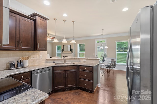 10806 Cove Point Dr, Charlotte, NC 28278 - kitchen with appliances with stainless steel finishes, a peninsula, dark brown cabinets, ornamental molding, and dark wood-type flooring