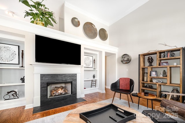 4937 S Hill View Dr, Charlotte, NC 28210 - living area with built in shelves, wood finished floors, a fireplace with flush hearth, and ornamental molding