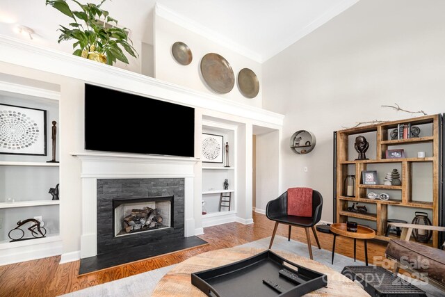 4937 S Hill View Dr, Charlotte, NC 28210 - living area featuring built in shelves, wood finished floors, crown molding, and a fireplace