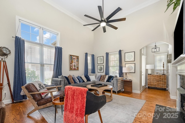 4937 S Hill View Dr, Charlotte, NC 28210 - living room with ceiling fan, healthy amount of natural light, crown molding, light wood finished floors, and a towering ceiling