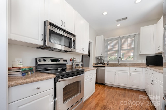 4937 S Hill View Dr, Charlotte, NC 28210 - kitchen featuring stainless steel appliances, white cabinetry, light wood-style flooring, and recessed lighting