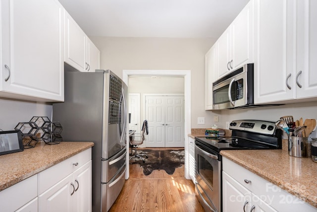 4937 S Hill View Dr, Charlotte, NC 28210 - kitchen with appliances with stainless steel finishes, light wood-type flooring, white cabinetry, and light stone countertops