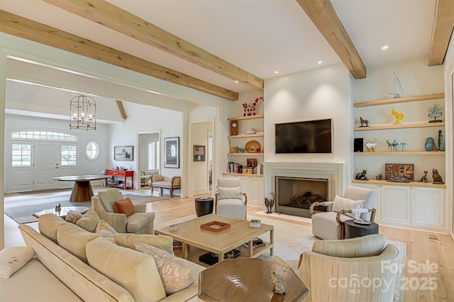 2632 Bartram Pl, Winston Salem, NC 27106 - living room featuring beamed ceiling, light wood-type flooring, a chandelier, a fireplace with flush hearth, and built in shelves