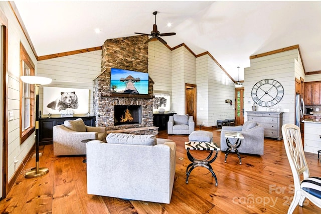 71 Raptor Way, Sapphire, NC 28774 - living room featuring ceiling fan, wood walls, light wood finished floors, a fireplace, and high vaulted ceiling