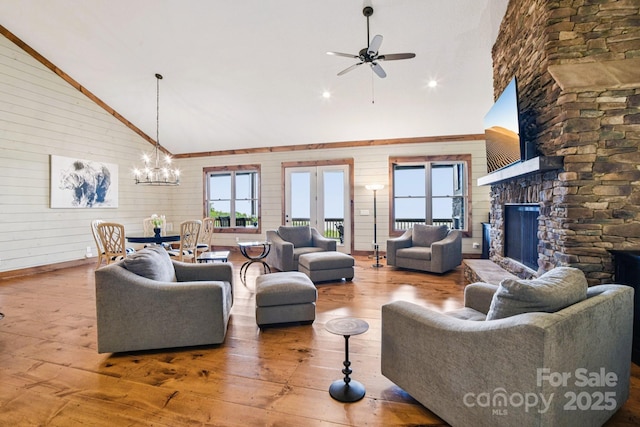 71 Raptor Way, Sapphire, NC 28774 - living area with ceiling fan, hardwood / wood-style floors, wood walls, a stone fireplace, and a chandelier
