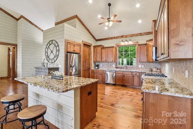 71 Raptor Way, Sapphire, NC 28774 - kitchen featuring appliances with stainless steel finishes, lofted ceiling, ceiling fan, a kitchen bar, and decorative backsplash