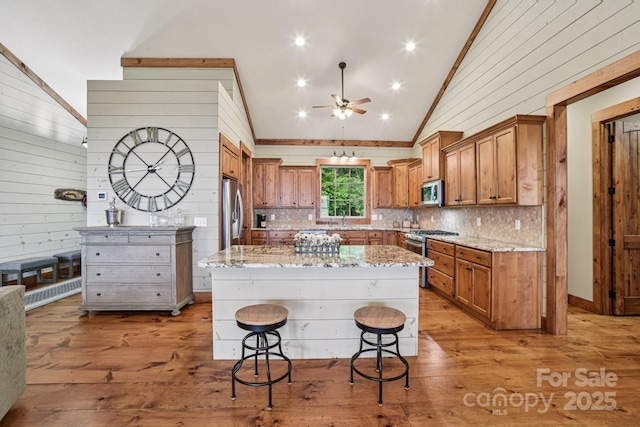 71 Raptor Way, Sapphire, NC 28774 - kitchen with appliances with stainless steel finishes, a ceiling fan, lofted ceiling, a kitchen breakfast bar, and tasteful backsplash