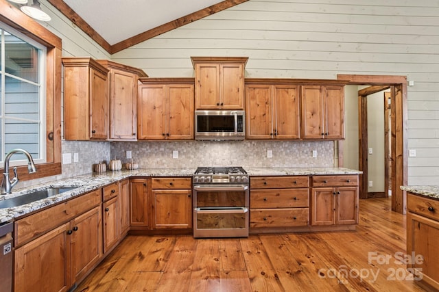71 Raptor Way, Sapphire, NC 28774 - kitchen featuring appliances with stainless steel finishes, vaulted ceiling, light wood-style flooring, backsplash, and wooden walls
