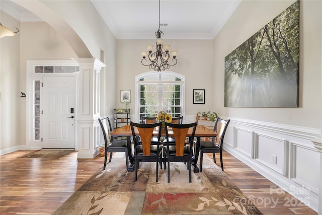 233 Highland Forest Dr, Clover, SC 29710 - dining room featuring arched walkways, wood finished floors, ornamental molding, a chandelier, and a towering ceiling