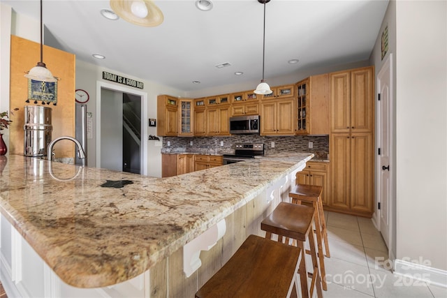 233 Highland Forest Dr, Clover, SC 29710 - kitchen with stainless steel appliances, brown cabinetry, tasteful backsplash, light stone countertops, and recessed lighting