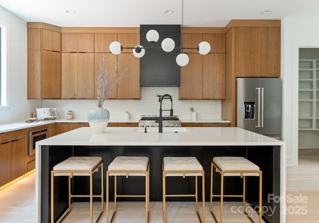 1727 Seifert Cir, Charlotte, NC 28205 - kitchen featuring high quality fridge, brown cabinetry, backsplash, light countertops, and a kitchen breakfast bar