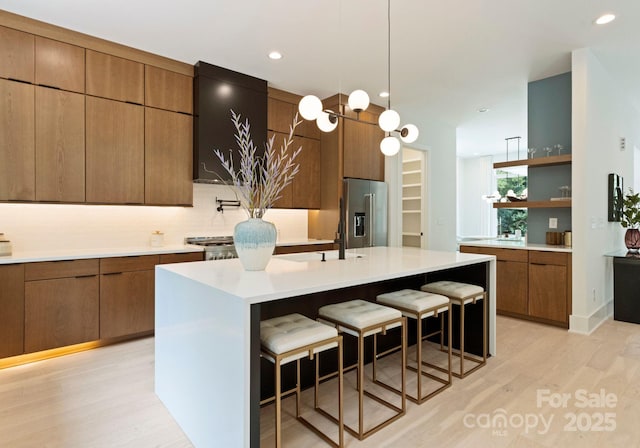 1727 Seifert Cir, Charlotte, NC 28205 - kitchen featuring stainless steel fridge with ice dispenser, open shelves, light wood finished floors, a breakfast bar area, and light countertops