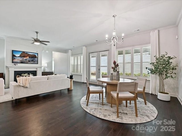 2034 Laney Pond Rd, Matthews, NC 28104 - dining area featuring crown molding, a chandelier, dark wood-type flooring, a ceiling fan, and a fireplace