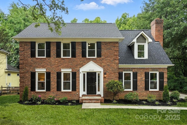 6542 Cross Field Ln, Charlotte, NC 28226 - colonial inspired home featuring a front yard, brick siding, a chimney, and roof with shingles
