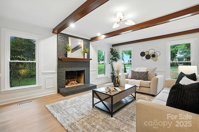 6542 Cross Field Ln, Charlotte, NC 28226 - living room with beamed ceiling, wood finished floors, a fireplace, and plenty of natural light