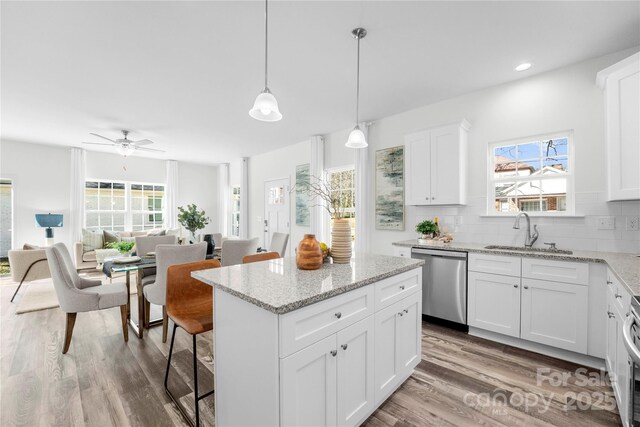 167 Dry Dock Loop, Mooresville, NC 28117 - kitchen with dishwasher, wood finished floors, a kitchen island, backsplash, and a ceiling fan