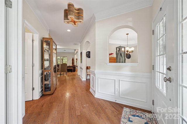 16833 Rudence Ct, Charlotte, NC 28278 - foyer with a chandelier, wood finished floors, arched walkways, ornamental molding, and a wainscoted wall