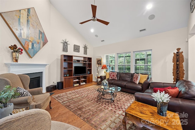 16833 Rudence Ct, Charlotte, NC 28278 - living room with high vaulted ceiling, ceiling fan, wood finished floors, a glass covered fireplace, and recessed lighting