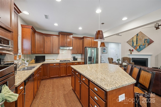 16833 Rudence Ct, Charlotte, NC 28278 - kitchen featuring stainless steel appliances, open floor plan, light wood-style floors, light stone countertops, and a kitchen island