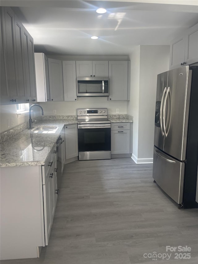 961 Poplar Forest Rdg, Clover, SC 29710 - kitchen with appliances with stainless steel finishes, light stone counters, recessed lighting, light wood-style flooring, and gray cabinets