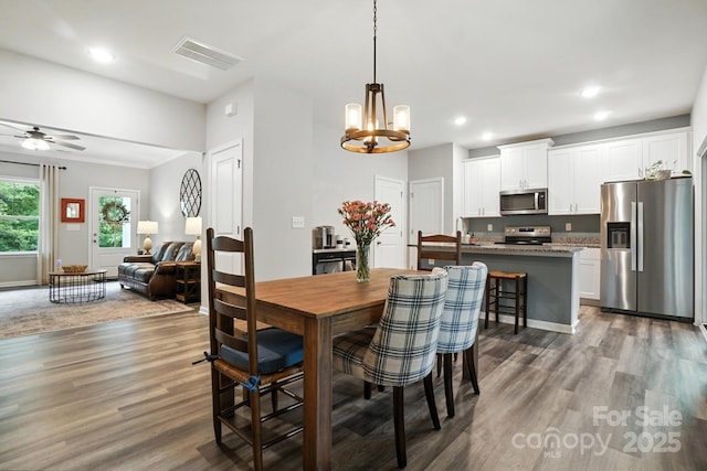 280 Mills Creek Rd, Iron Station, NC 28080 - dining room with wood finished floors, a chandelier, ceiling fan, and recessed lighting