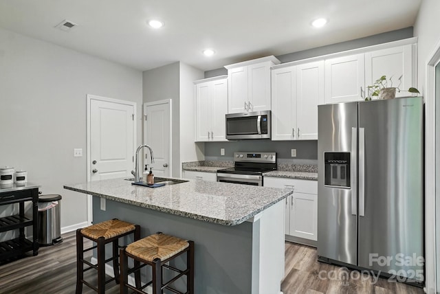 280 Mills Creek Rd, Iron Station, NC 28080 - kitchen with appliances with stainless steel finishes, dark wood-style flooring, a center island with sink, white cabinets, and recessed lighting