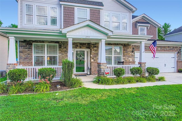 2599 Treeline Dr, Concord, NC 28027 - view of front of house with covered porch, concrete driveway, a front yard, and stone siding