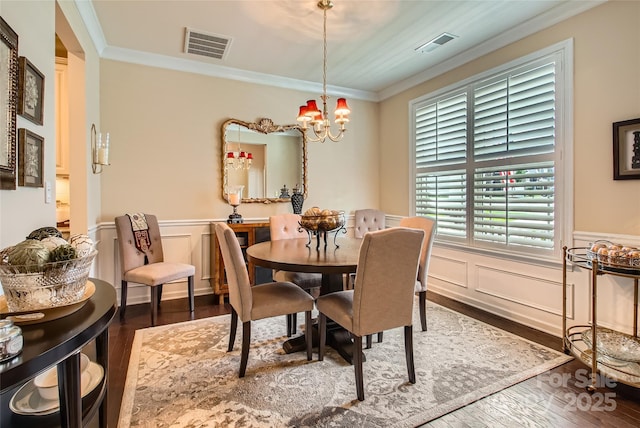 2599 Treeline Dr, Concord, NC 28027 - dining area with crown molding, wood finished floors, a chandelier, wainscoting, and a decorative wall