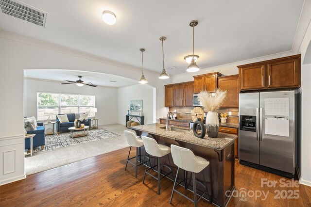 9706 Thyme Ct, Charlotte, NC 28214 - kitchen featuring stainless steel appliances, light stone countertops, a breakfast bar, open floor plan, and decorative backsplash