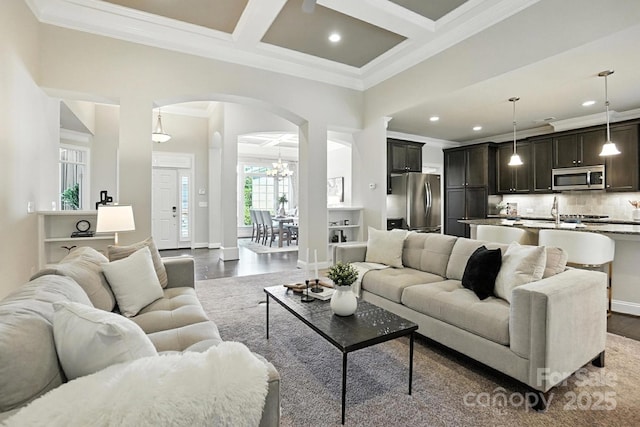 551 Brightleaf Pl NW, Concord, NC 28027 - living room with arched walkways, dark wood-type flooring, crown molding, recessed lighting, and beam ceiling