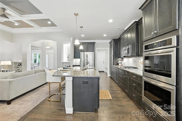 551 Brightleaf Pl NW, Concord, NC 28027 - kitchen with appliances with stainless steel finishes, open floor plan, ceiling fan, crown molding, and arched walkways