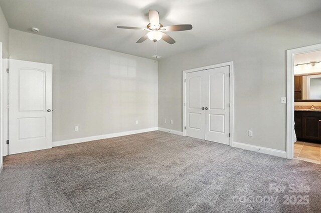 551 Brightleaf Pl NW, Concord, NC 28027 - unfurnished bedroom featuring light colored carpet, ensuite bathroom, ceiling fan, and a closet
