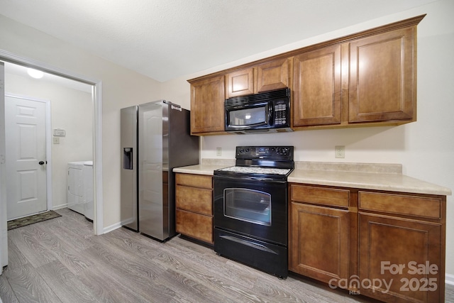 374 Morning Dew Dr, Concord, NC 28025 - kitchen featuring black appliances, light wood finished floors, washer / clothes dryer, and light countertops