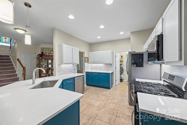 7029 Scuppernong Ct, Charlotte, NC 28215 - kitchen featuring appliances with stainless steel finishes, blue cabinets, decorative backsplash, light countertops, and white cabinets