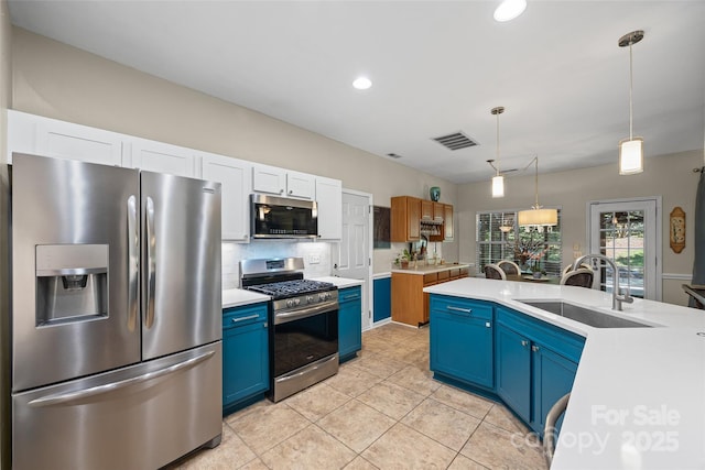 7029 Scuppernong Ct, Charlotte, NC 28215 - kitchen with appliances with stainless steel finishes, blue cabinets, light countertops, pendant lighting, and tasteful backsplash