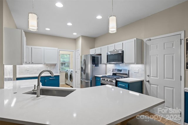 7029 Scuppernong Ct, Charlotte, NC 28215 - kitchen with independent washer and dryer, stainless steel appliances, decorative backsplash, light countertops, and blue cabinetry