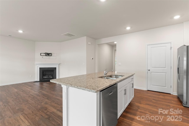 3505 Sycamore Crossing Ct, Mount Holly, NC 28120 - kitchen with stainless steel appliances, dark wood-style floors, white cabinetry, a kitchen island with sink, and light stone counters