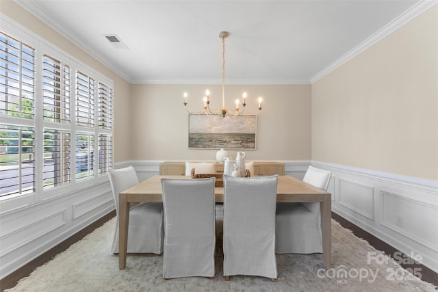17514 Julees Walk Ln, Davidson, NC 28036 - dining room with a chandelier, crown molding, a wainscoted wall, a decorative wall, and light wood-style floors