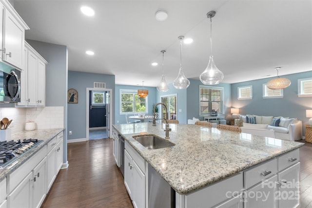 17514 Julees Walk Ln, Davidson, NC 28036 - kitchen with stainless steel appliances, a kitchen island with sink, dark wood-type flooring, recessed lighting, and white cabinets