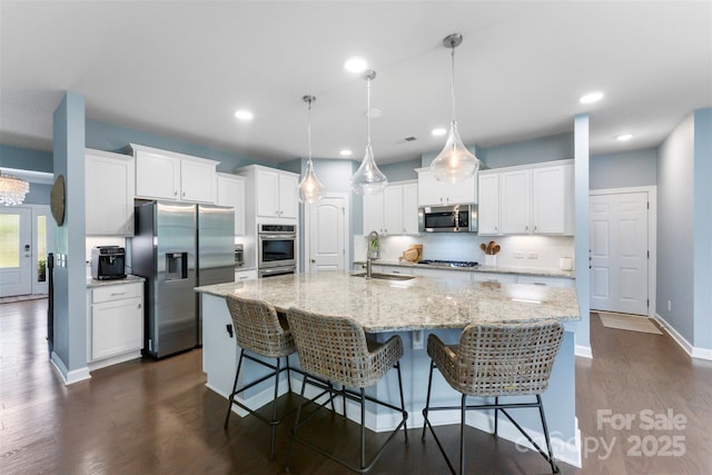 17514 Julees Walk Ln, Davidson, NC 28036 - kitchen with stainless steel appliances, dark wood-style flooring, decorative backsplash, a spacious island, and white cabinetry