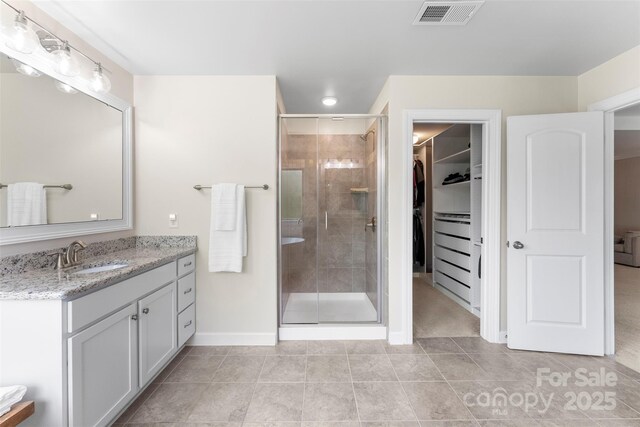 17514 Julees Walk Ln, Davidson, NC 28036 - full bath with vanity, a shower stall, a walk in closet, and tile patterned flooring