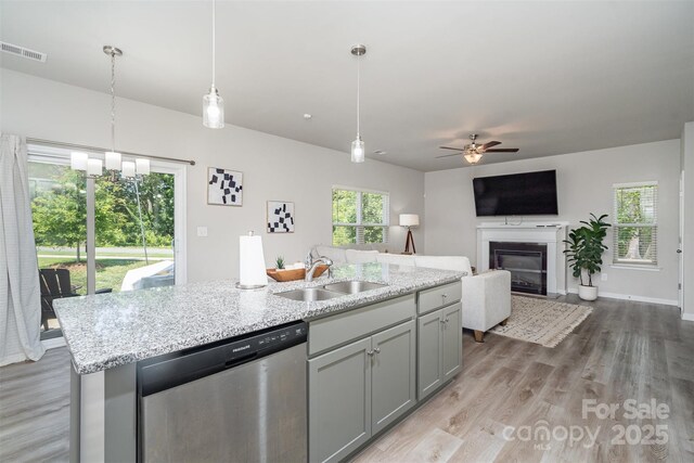 2014 Karen Woods Ln, Charlotte, NC 28216 - kitchen with dishwasher, ceiling fan, a glass covered fireplace, and light wood-style flooring
