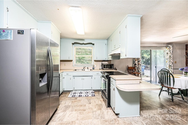 1008 2nd St SE, Conover, NC 28613 - kitchen with appliances with stainless steel finishes, a textured ceiling, a peninsula, light countertops, and under cabinet range hood