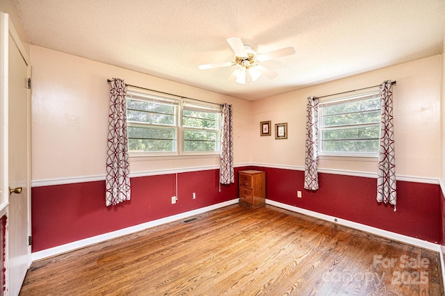 1008 2nd St SE, Conover, NC 28613 - empty room with healthy amount of natural light, wood finished floors, ceiling fan, and a textured ceiling
