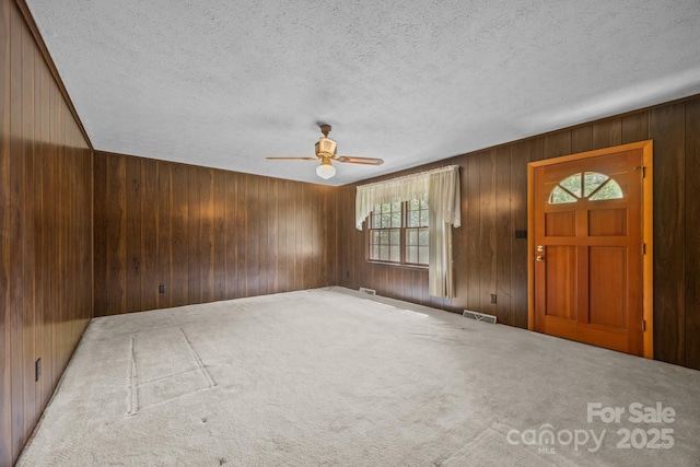 18 Progress Ln, Candler, NC 28715 - carpeted foyer entrance featuring a ceiling fan, wood walls, and a textured ceiling