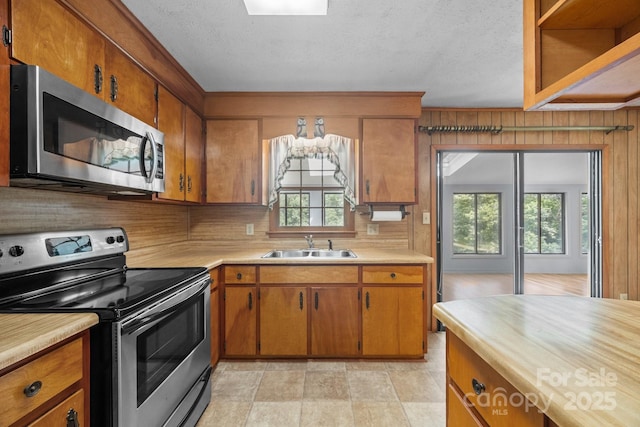 18 Progress Ln, Candler, NC 28715 - kitchen with stainless steel appliances, light countertops, brown cabinetry, and a textured ceiling